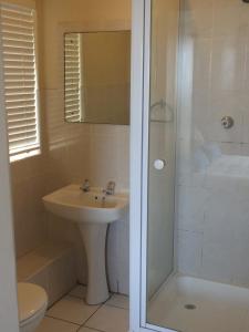 a bathroom with a shower and a sink and a toilet at Dolphins Nook in Summerstrand