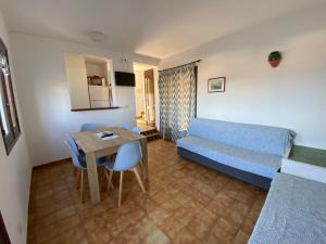a living room with a blue couch and a table at Apartamentos Sa Cornisa in Cala Morell