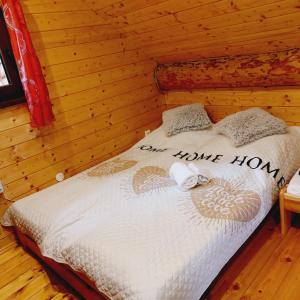 a bed in a log cabin with the words are home how at Kanadský zrub in Prievidza