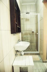 y baño con lavabo y ducha acristalada. en LA CASETTA BED & BREAKFAST, en Swakopmund