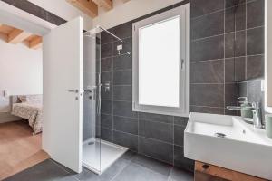Un baño con ducha, lavabo y espejo. en Palazzo '900 Design Flats - Il Gran Salone, en Padua