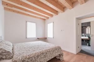 a white bedroom with a bed and two windows at Palazzo '900 Design Flats - Il Gran Salone in Padova