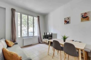 a living room with a table and a couch at Cozy apartment F3 with barbecue in Le Bourget