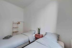 two beds sitting next to each other in a room at Cozy apartment F3 with barbecue in Le Bourget