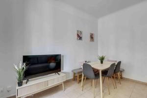 a living room with a table and a tv at Cozy apartment F3 with barbecue in Le Bourget