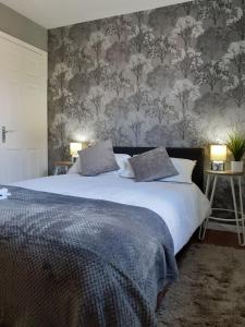 ein Schlafzimmer mit einem großen Bett mit Blumentapete in der Unterkunft Hardwick Haven, Sedgefield - Near Hardwick Hall in Stockton-on-Tees