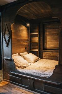 um quarto com uma cama grande num quarto de madeira em Chalet Camillou em Champagny-en-Vanoise