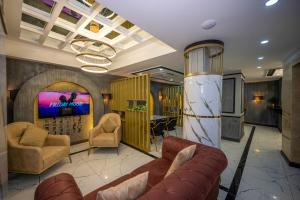 a lobby with a couch and chairs and a tv at Hotel California in Istanbul