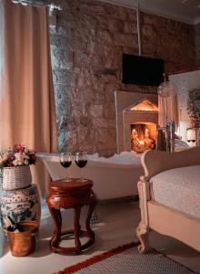Sala de estar con 2 copas de vino y chimenea en Hoşça kal Alaçatı en Alacati