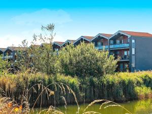 6 person holiday home in Bogense في بوجنسي: مبنى بجانب تجمع المياه بالعشب