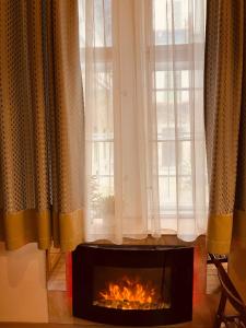 a fireplace in front of a window with curtains at Veres Pálné in Budapest