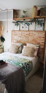 een slaapkamer met een groot bed met een houten hoofdeinde bij OH ! MADIANA in Saint-Jean-dʼIllac