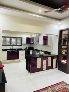 cocina grande con armarios púrpuras y electrodomésticos blancos en Castle Villa, en Ernakulam