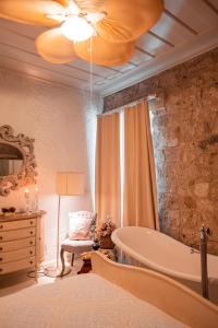 a bathroom with a tub and a bed with a lamp at Hoşça kal Alaçatı in Alaçatı