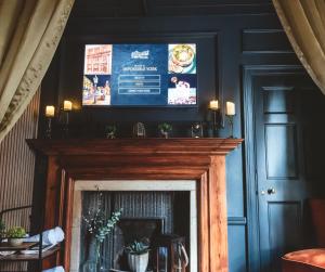 a fireplace with a flat screen tv above it at Impossible Motel in York
