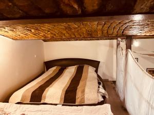 a bed in a small room with a wooden ceiling at Veres Pálné in Budapest