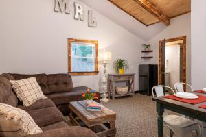 a living room with a couch and a table at Mad River Lodge in Waitsfield