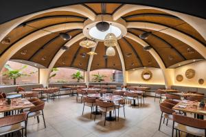 a restaurant with wooden ceilings and tables and chairs at Barceló Tenerife Royal Level in San Miguel de Abona