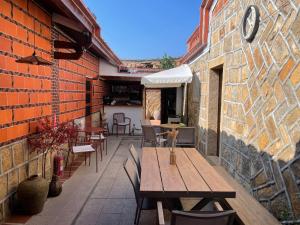 un patio con tavolo e sedie in legno su un edificio in mattoni di Zhu Shan Xian Ting a Jincheng