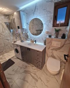 a bathroom with a sink and a toilet and a mirror at Avram in Zlatibor