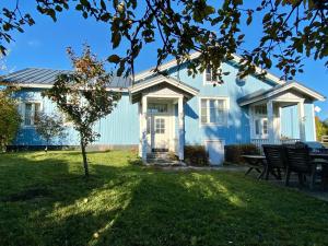 una casa azul con una mesa de picnic en el patio en Mäkisen Majatalo en Palus