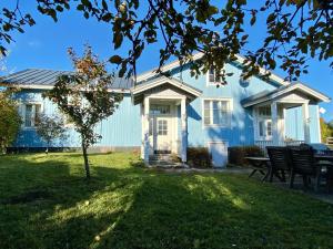 a blue house with a picnic table in the yard at Mäkisen Majatalo in Palus