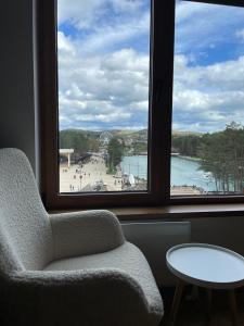 a room with a chair and a window with a view of a beach at Avram in Zlatibor