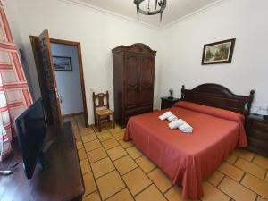 a bedroom with a bed with two towels on it at Hotel-Restaurante Venta Tomas in Almuradiel