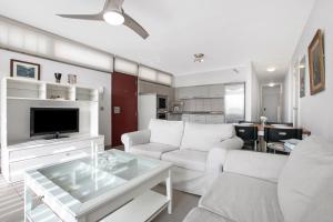 sala de estar con 2 sofás blancos y TV en Casa Médano 3 By Médano Rentals, en El Médano