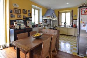 una cocina con una mesa de madera y un bol de fruta. en Posada Casa de Valle, en Colindres