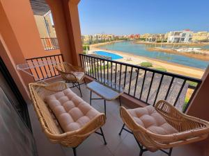 een balkon met stoelen en uitzicht op een rivier bij Lily's Place - Scenic Lagoon View at Tawila, Gouna in Hurghada