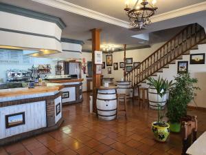 a restaurant with a bar and a staircase at Hotel-Restaurante Venta Tomas in Almuradiel