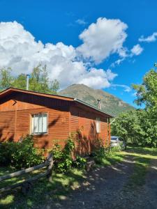 eine Holzhütte mit einem Berg im Hintergrund in der Unterkunft Cabañas Nativa in San Fabián de Alico