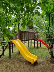 a playground with a yellow slide in a park at Cabañas Nativa in San Fabián de Alico