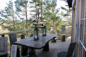 una mesa de madera con luces en una terraza de madera en Tretopphytter På Grensen - Elghytta med robåt og gjeddefiske en Halden