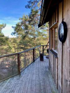 eine hölzerne Veranda eines Hauses mit einem Fenster in der Unterkunft Tretopphytter På Grensen - Elghytta med robåt og gjeddefiske in Halden