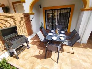 a patio with a table and chairs and a grill at Casa Pedro in Benaoján