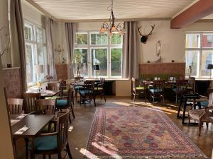 a restaurant with tables and chairs and a rug at Bahnhofshotel Die Neue Bühne in Bad Saarow