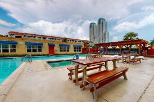 a pool with tables and benches next to a building at Gulfview I #201 in South Padre Island
