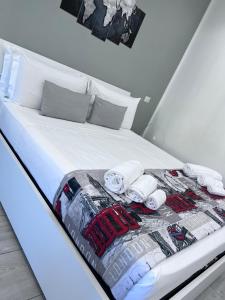 uma cama com lençóis brancos e toalhas em One Hundred Rooms em Roma