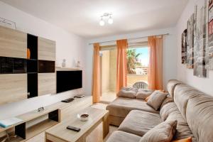 a living room with a couch and a tv at La Perla D14 en el Médano in El Médano