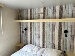 sypialnia z drewnianą ścianą i łóżkiem w obiekcie Comfortabele familie chalets met veranda incl airco dichtbij zee! w Viareggio