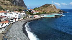 a view of a beach with buildings and the ocean at Souza Beach Apartment - Porto da Cruz - Studio & Suite in Porto da Cruz