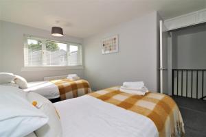 a bedroom with two beds and a window at Signature - Morland House in East Kilbride