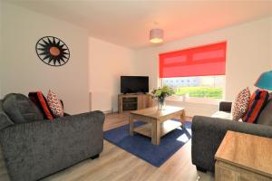 a living room with two couches and a television at Signature - Sydney House in East Kilbride