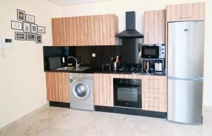 a kitchen with a refrigerator and a washing machine at Appartement Cosy, vue sur mer in Mohammedia