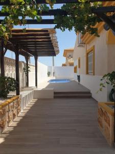 洪達海灘的住宿－Dúplex mediterráneo con piscina y cenador，通往带木屋顶的建筑的走道