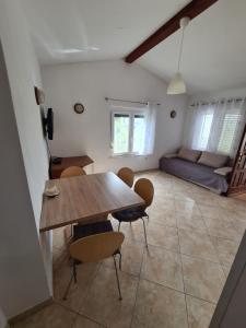 a dining room with a table and chairs and a couch at Apartma z dvema spalnicama in teraso in Portorož