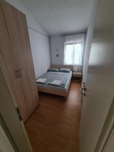 a small bedroom with a bed and a window at Apartma z dvema spalnicama in teraso in Portorož