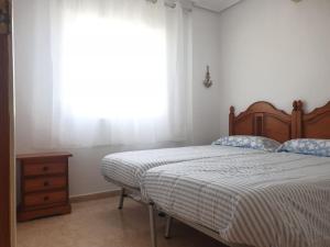 洪達海灘的住宿－Dúplex mediterráneo con piscina y cenador，一间卧室设有一张床和一个窗口